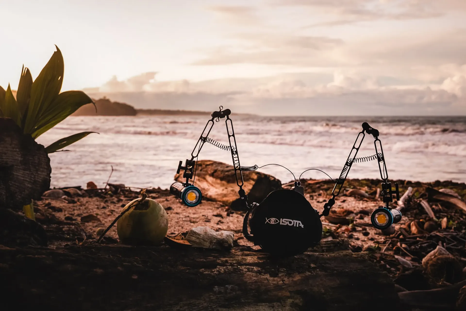 Underwater camera rig and strobes set up on a driftwood log at a beach sunset — behind the scenes on assignment